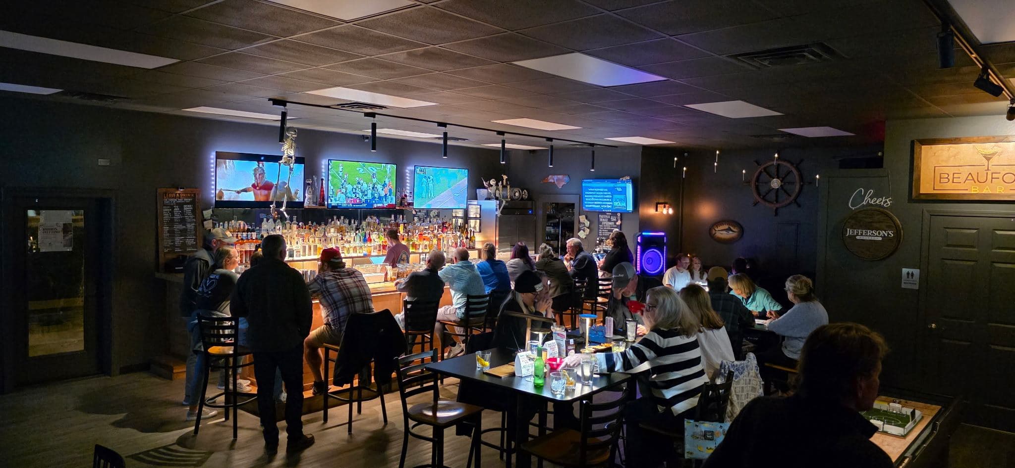 Inside Beaufort Bar — the long wood bar, screens on, a full room
